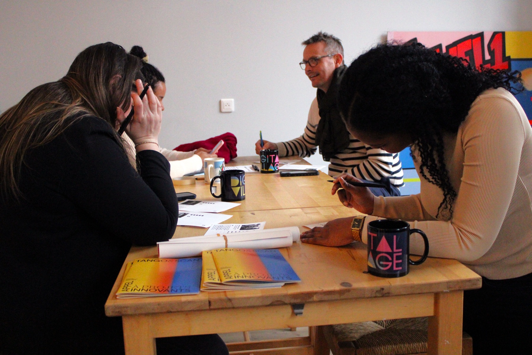 Atelier de travail autour d'une table, documents ouverts